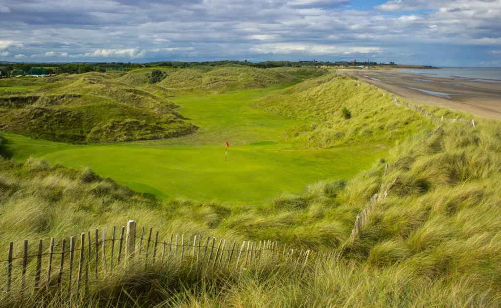 Gold course in small valley beside beach