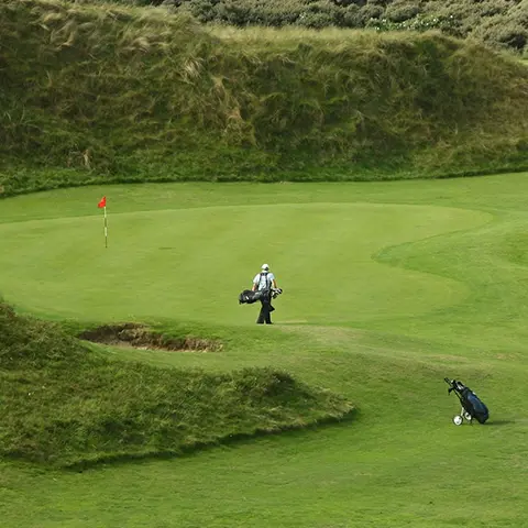Man walking across green